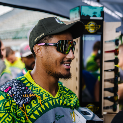 Man wearing a black cap and sunglasses with a colorful shirt