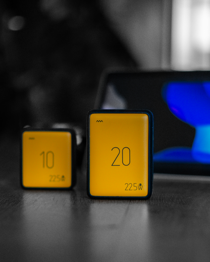 Two powerbanks on a dark surface with a blurred background